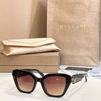Black square eyeglasses with dark-tinted lenses and gold-tone temple accent.