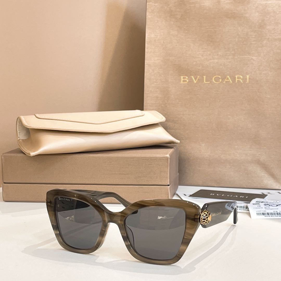 Dark brown square glasses with gray-tinted lenses and gold-tone temple emblem.