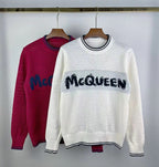 Crewneck knit sweater in magenta with blue McQueen logo across the chest