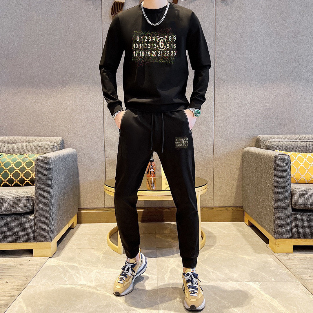 Maison Margiela black sweatshirt and track pants set with front graphic, worn with sneakers