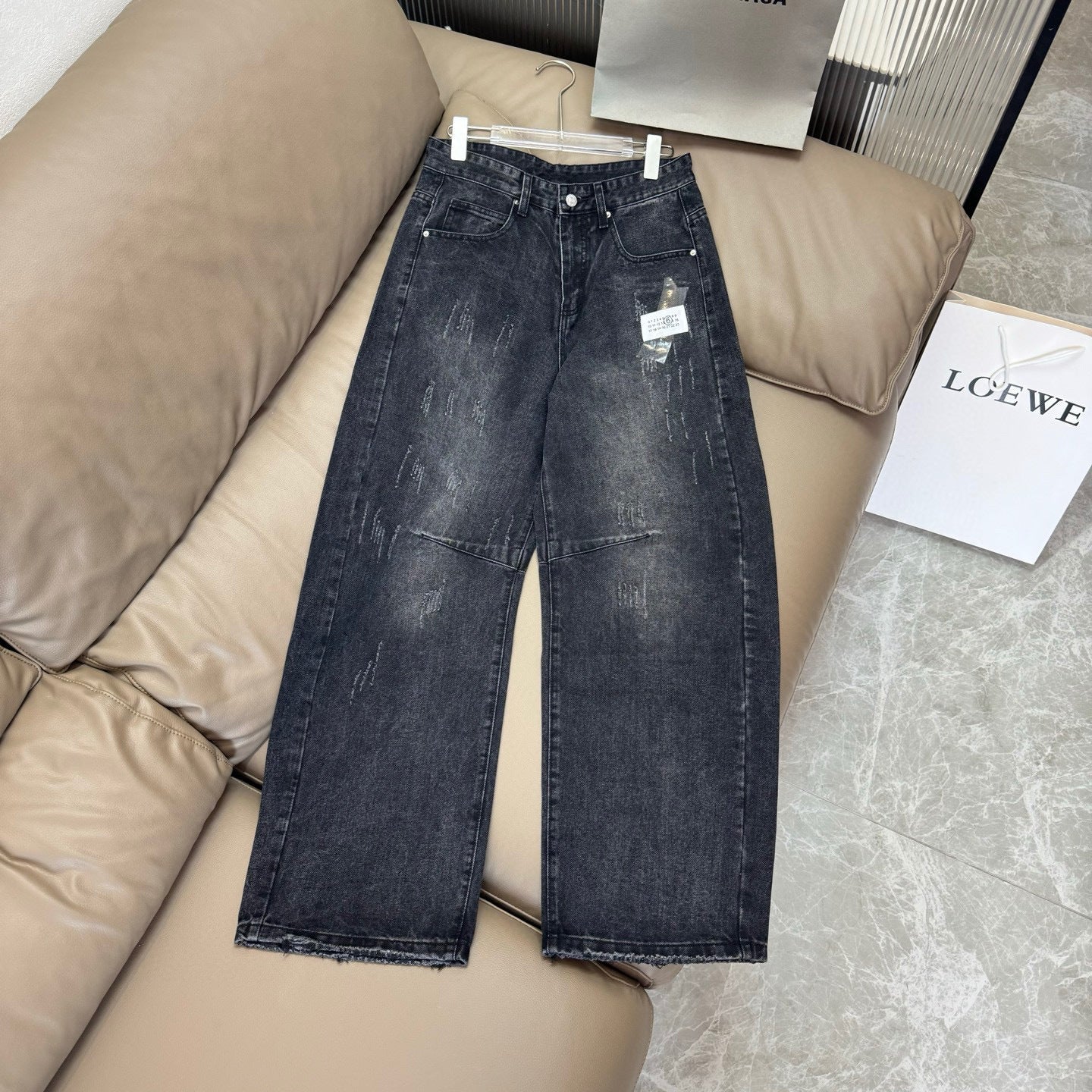 Maison Margiela dark wash denim jeans with wide legs and frayed hem