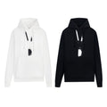 Pullover hoodies, one white and one black, with drawstring hood and hanging tag