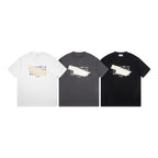 Three crew-neck T-shirts in white, charcoal, and black with Maison Margiela front graphics
