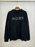 Dark knit sweater with crew neck and McQUEEN logo on front
