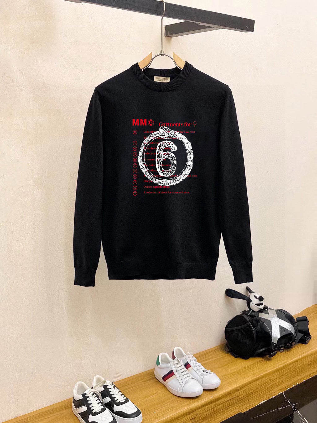 Black crewneck sweatshirt with long sleeves and “6” graphic print on chest
