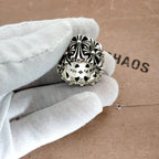 Silvertone ornate ring with scalloped edge and star detail on a white glove