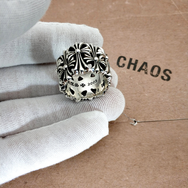 Silvertone ornate ring with scalloped bezel and cross-hatch accents on a glove