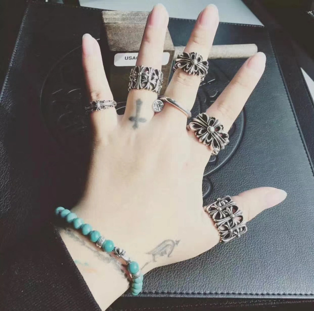 Silvertone floral rings set on open hand, with matching bracelet and cuff