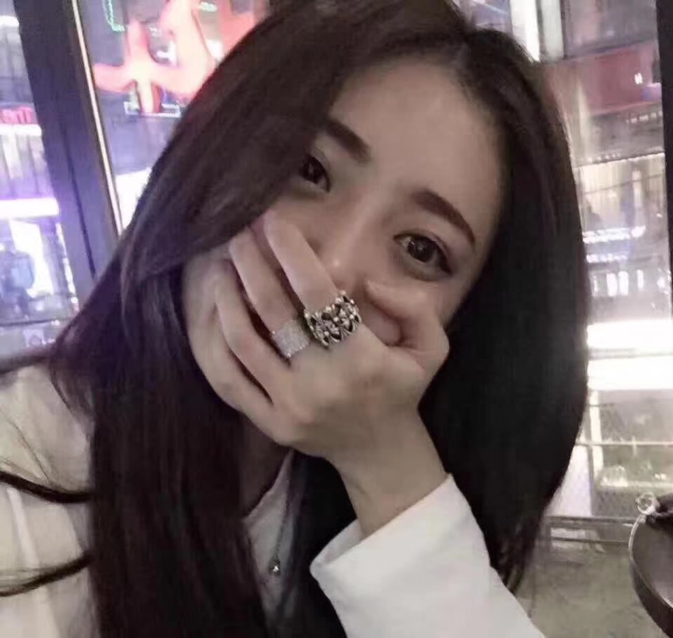 Silvertone ornate rings on fingers, hands posed near a display counter