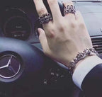 Silvertone floral rings on hand with a matching bracelet cuff