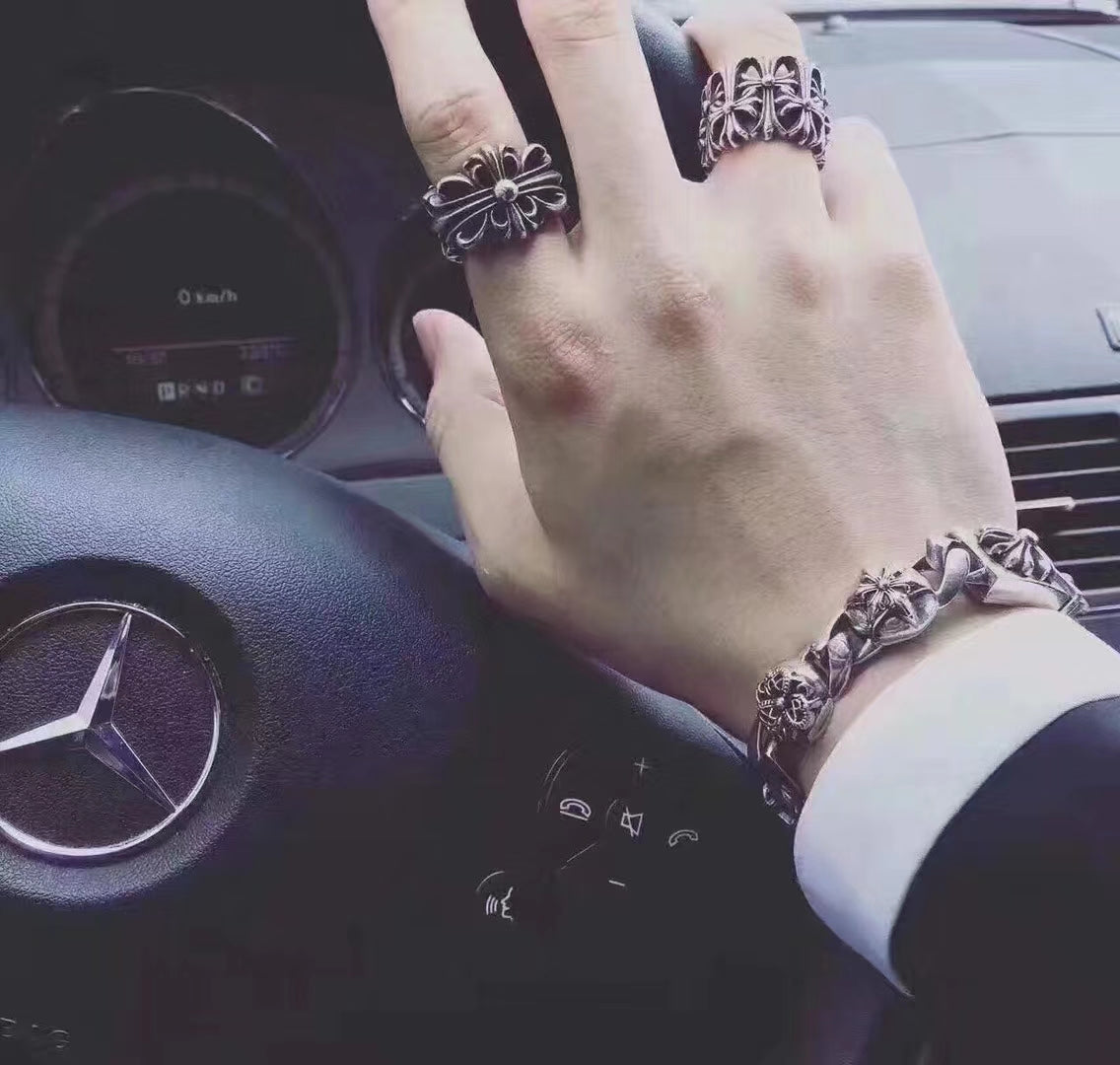 Silvertone floral rings on hand with a matching bracelet cuff