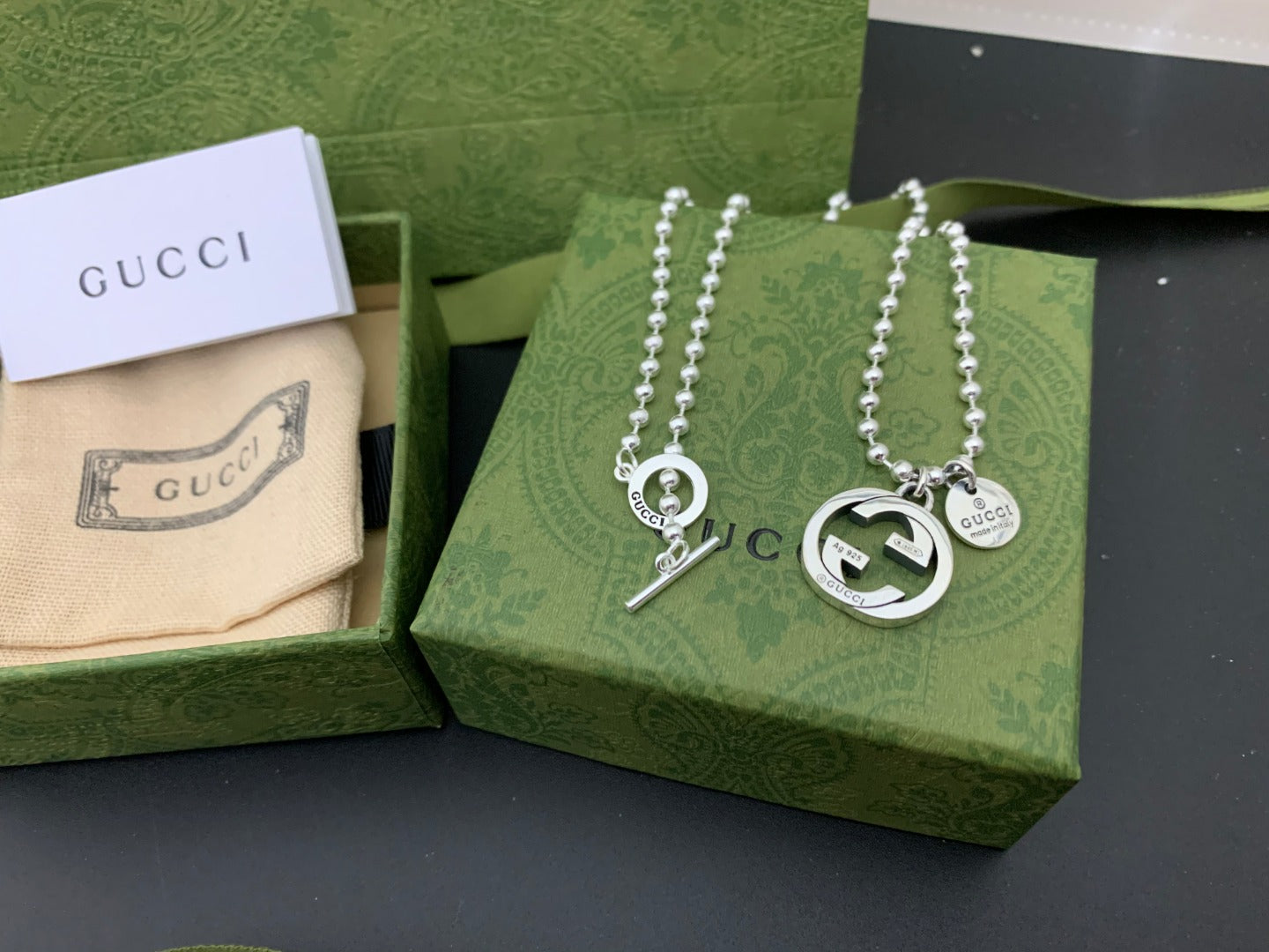 Silver charm necklace set with round GUCCI pendants and dangling letter charm