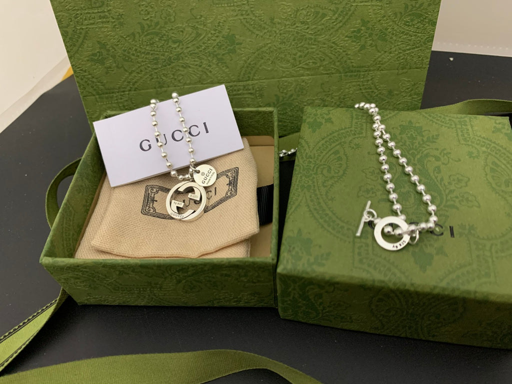 Silver chain necklace with round GUCCI logo pendant and small dangling charm