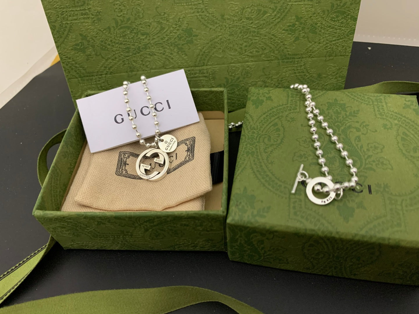 Silver chain necklace with round GUCCI logo pendant and small dangling charm