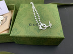 Silver chain necklace with round GUCCI pendant and heart-shaped outline charm