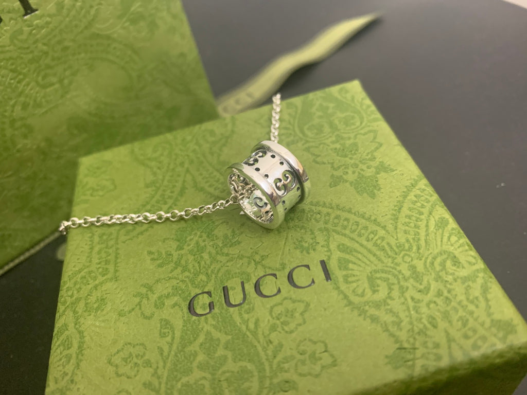 Square silver Gucci pendant with engraved details on a chain