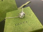Square silver Gucci pendant with engraved details on a chain