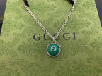 Gucci pendant necklace close-up with green round medallion and silver chain