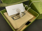 Silver-tone layered necklace with round interlocking G pendant and dangling charms