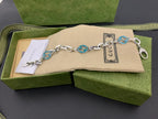 Silver-tone chain bracelet with blue enamel logo discs and dark logo plaque charm