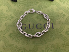 Silver-tone chain bracelet with blue enamel logo discs and silver curb links, top view