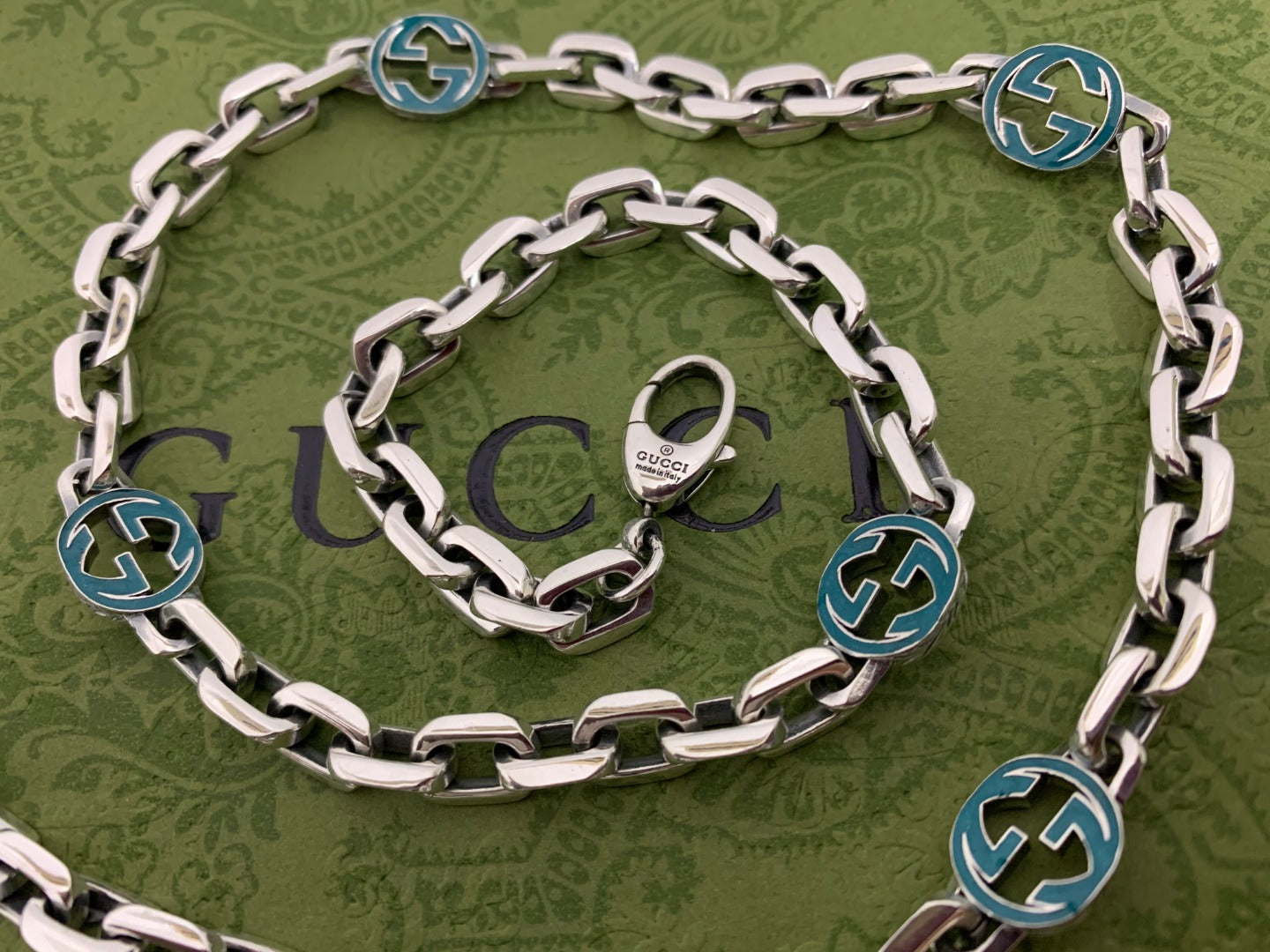 Silver chain strap with blue interlocking G charms and central clasp