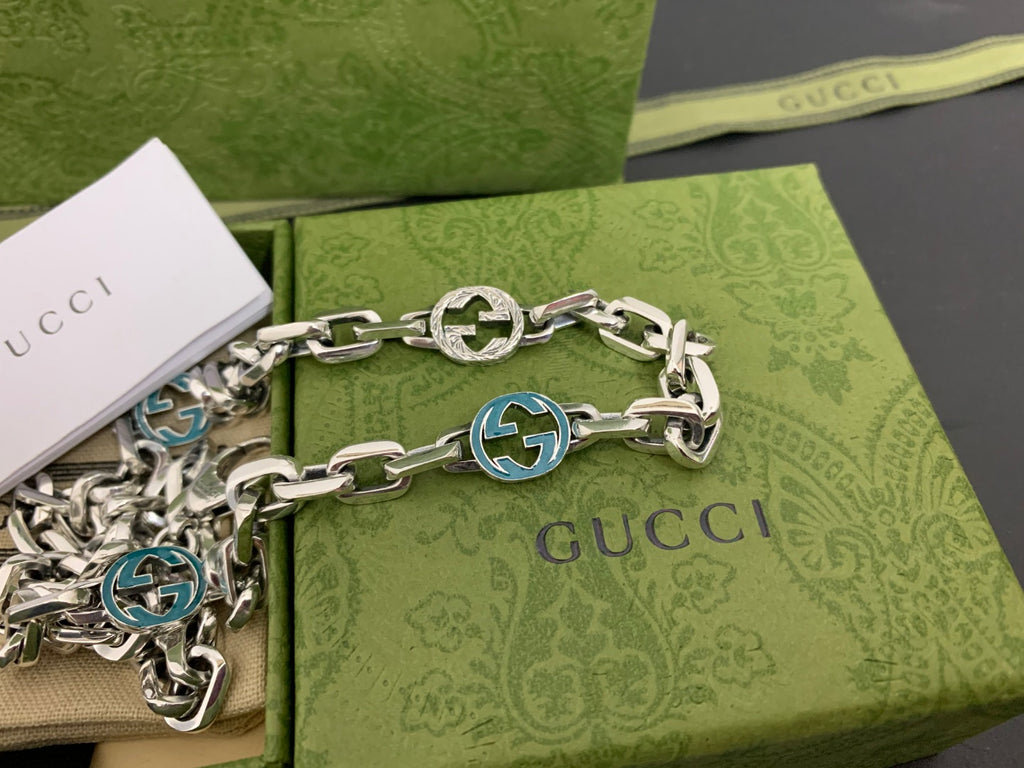 Silver chain strap with blue interlocking G medallions and clasp
