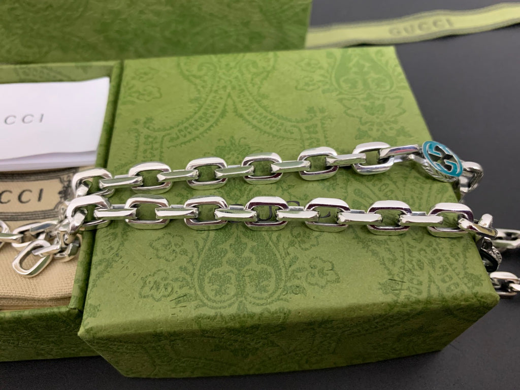 Silver chain strap with blue interlocking G charm near clasp