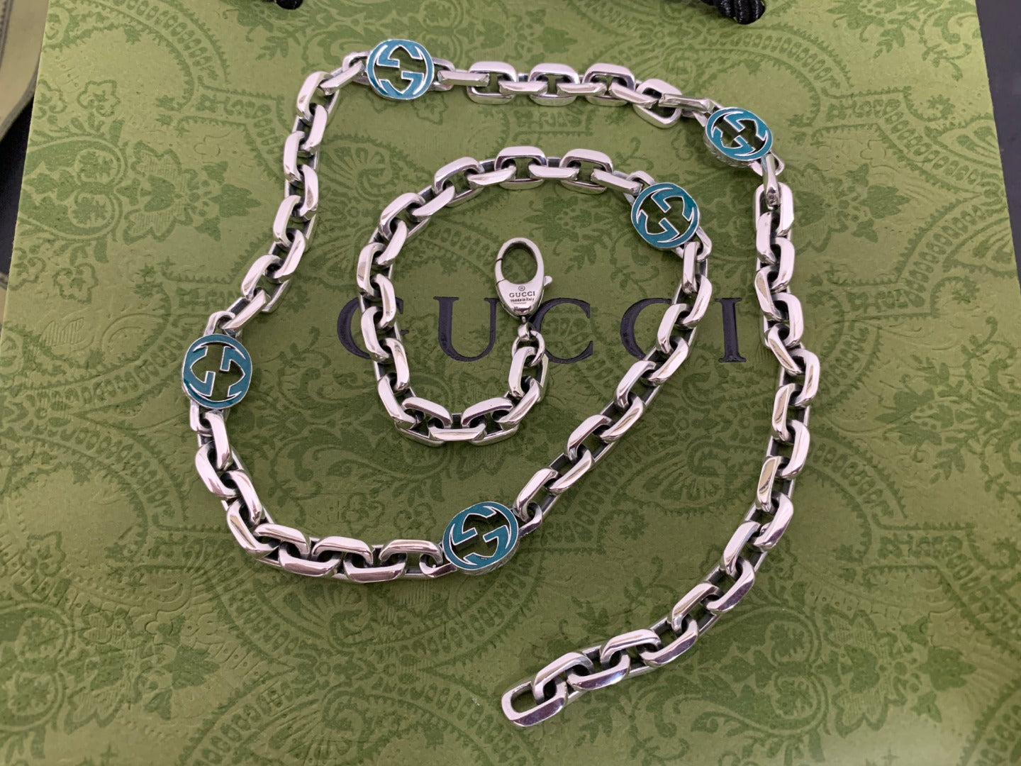 Silver chain strap with blue interlocking G medallions and rings