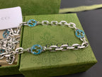 Silver chain strap with blue interlocking G medallions and clasp