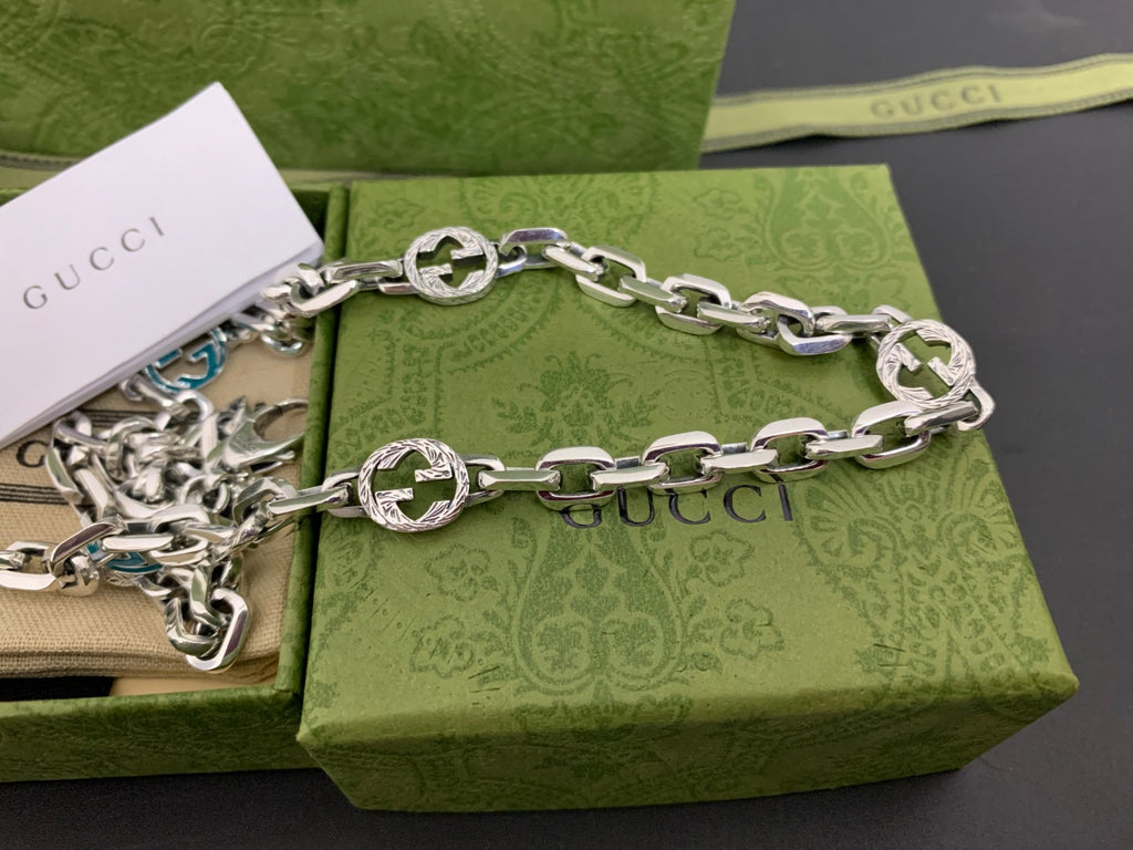 Silver chain strap with blue interlocking G links and decorative charm