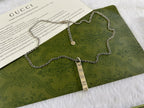 Gucci necklace with silver chain and rectangular GG charm pendant with round disc