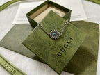 Silver charm bracelet with turquoise center flower and small logo links.