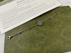 Silver charm bracelet with turquoise flower medallion and oval logo chain links.