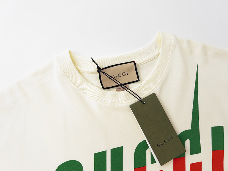 Cream T-shirt neckline with Gucci tag and partial green logo print