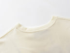 Cream crew-neck T-shirt neckline detail with ribbed collar
