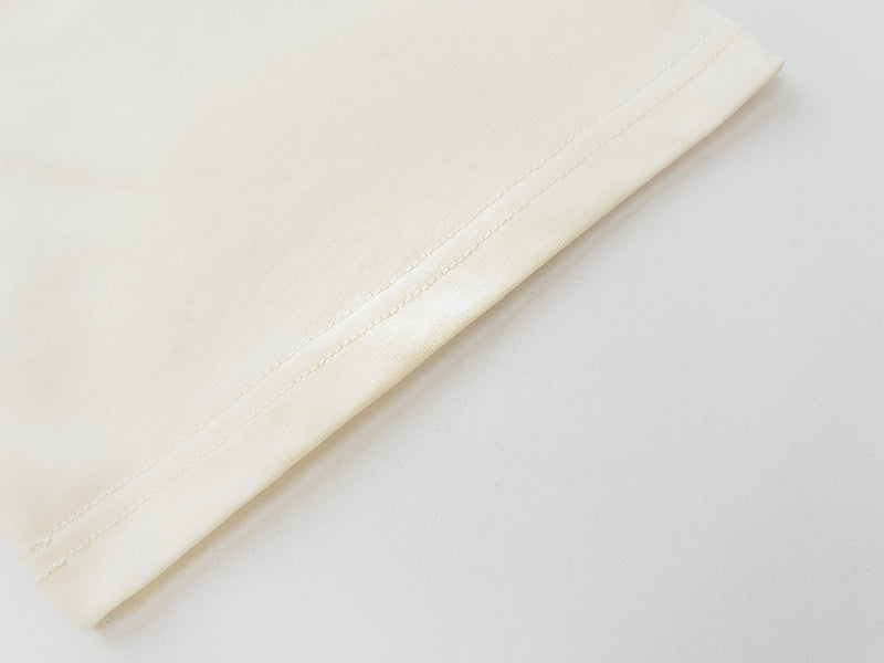 Cream T-shirt sleeve cuff detail with stitched seam