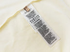 Cream T-shirt inside care label and size tag near hem