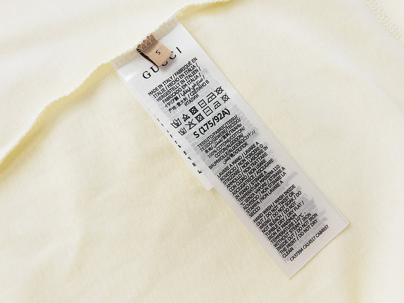 Cream T-shirt inside care label and size tag near hem