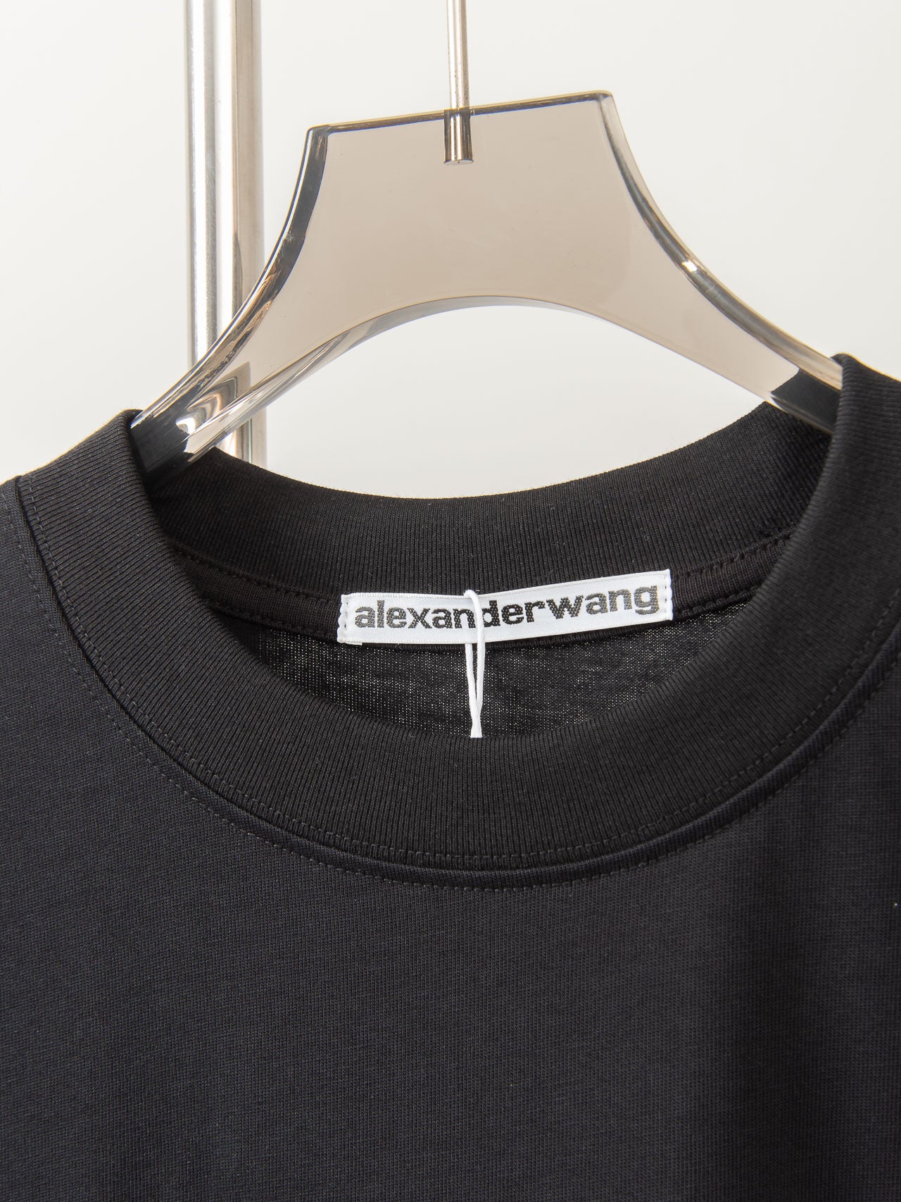 Black crew-neck T-shirt collar with alexanderwang brand label inside neckline