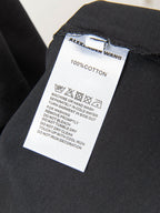 Black T-shirt care label: 100% cotton and machine wash instructions