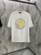 White T-shirt with large round gold-and-blue graphic on the chest