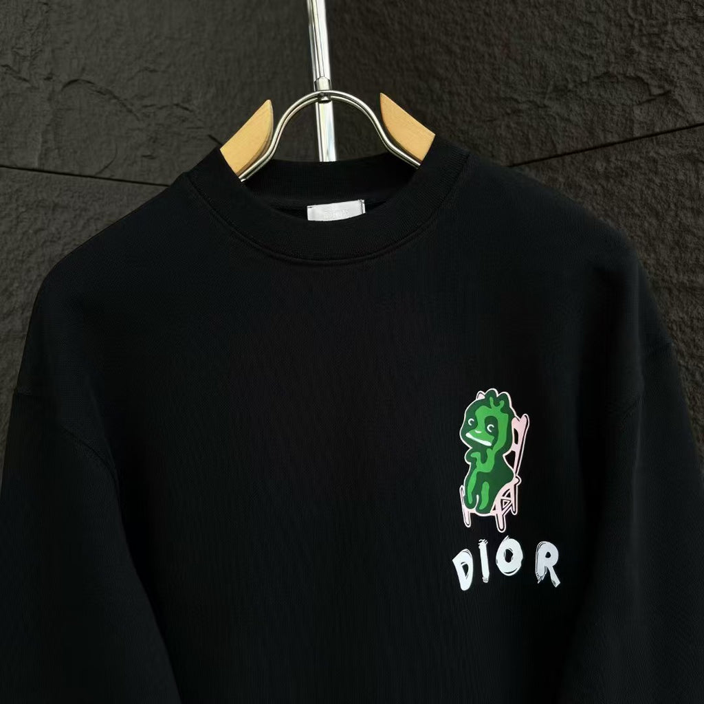 Black crewneck sweatshirt with green character graphic and DIOR logo on the chest.