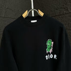 Black crewneck sweatshirt with green character graphic and DIOR logo on the chest.