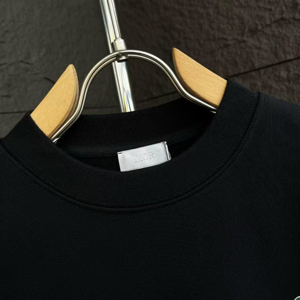 Black crewneck sweatshirt collar with interior label at the neckline.