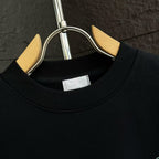 Black crewneck sweatshirt collar with interior label at the neckline.