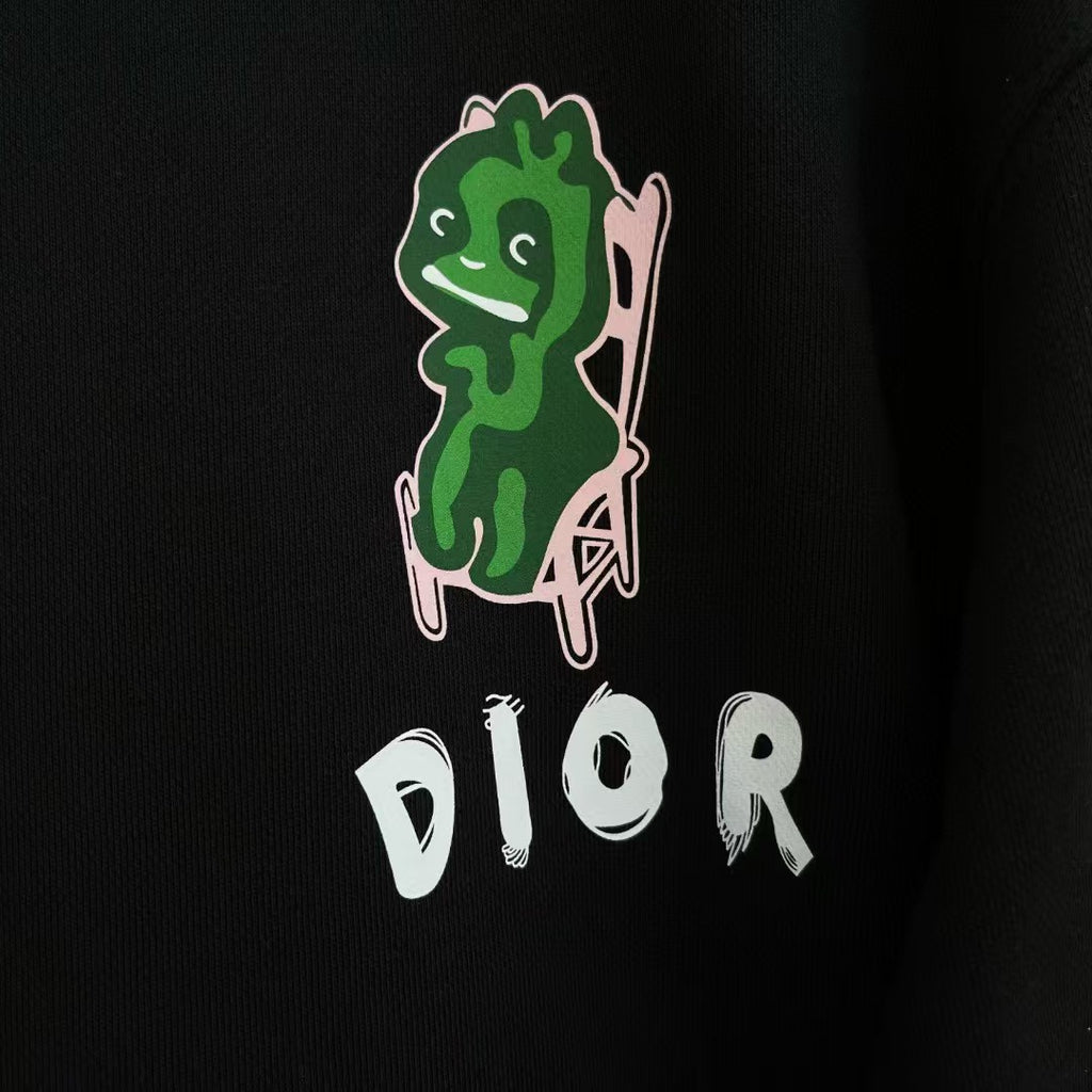 Black crewneck sweatshirt with green character graphic and white DIOR logo on front.