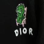 Black crewneck sweatshirt with green character graphic and white DIOR logo on front.
