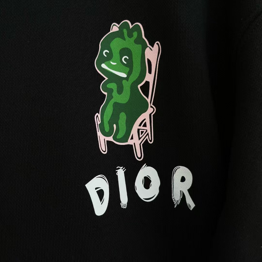Black crewneck sweatshirt with green character graphic and white DIOR logo on front.