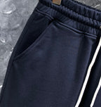 Dark navy sweatpants with elastic waistband and angled side seam